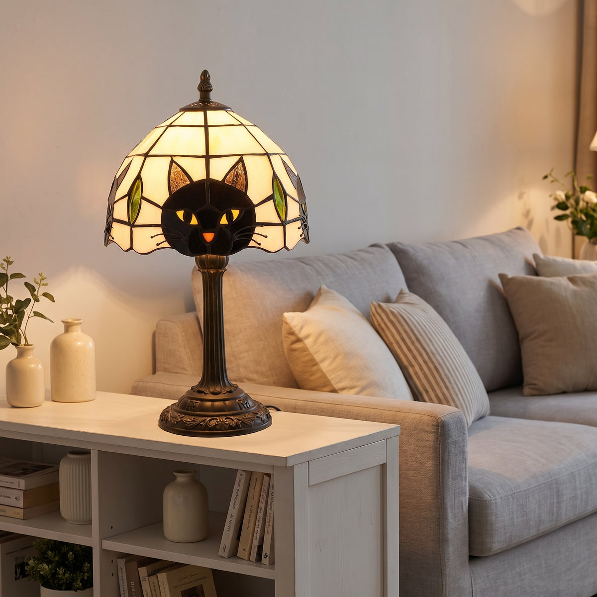 Lampe style Tiffany Chat gris allumée sur une bibliothèque dans un salon clair