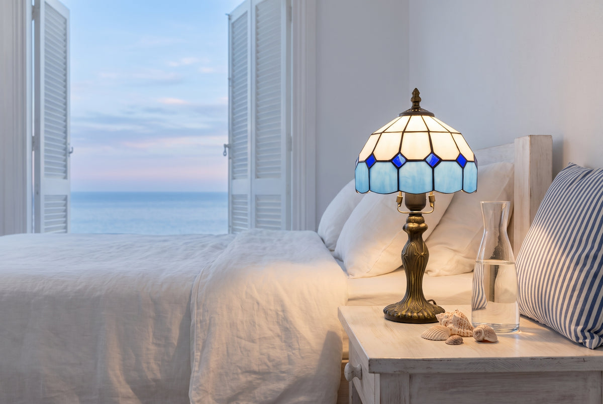 Lampe style Tiffany bleue sur une table de chevet face à la mer
