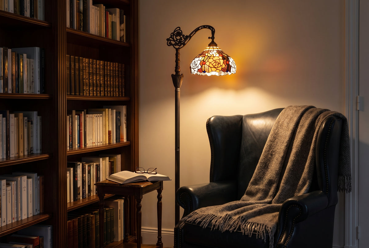 Lampadaire liseuse style Tiffany allumé dans un coin lecture, fauteuil et bibliothèque