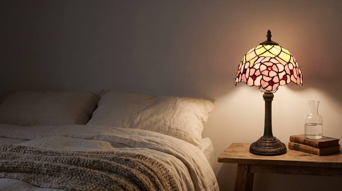 Lampe en vitrail à fleurs de cerisier allumée sur une table de chevet